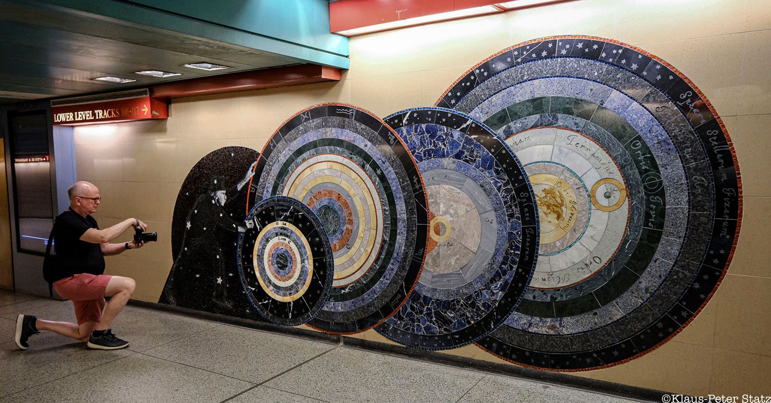 Man taking a photo of a mosaic in Grand Central