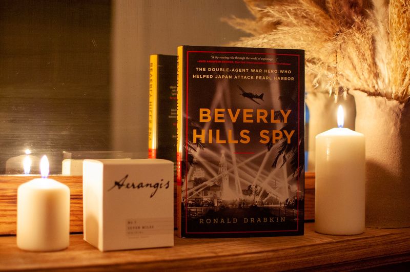 Beverly Hills Spy book on a mantel covered with candles