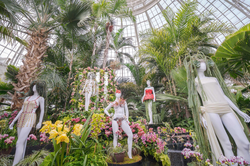 Mannequins scattered throughout a conservatory garden at NYBG