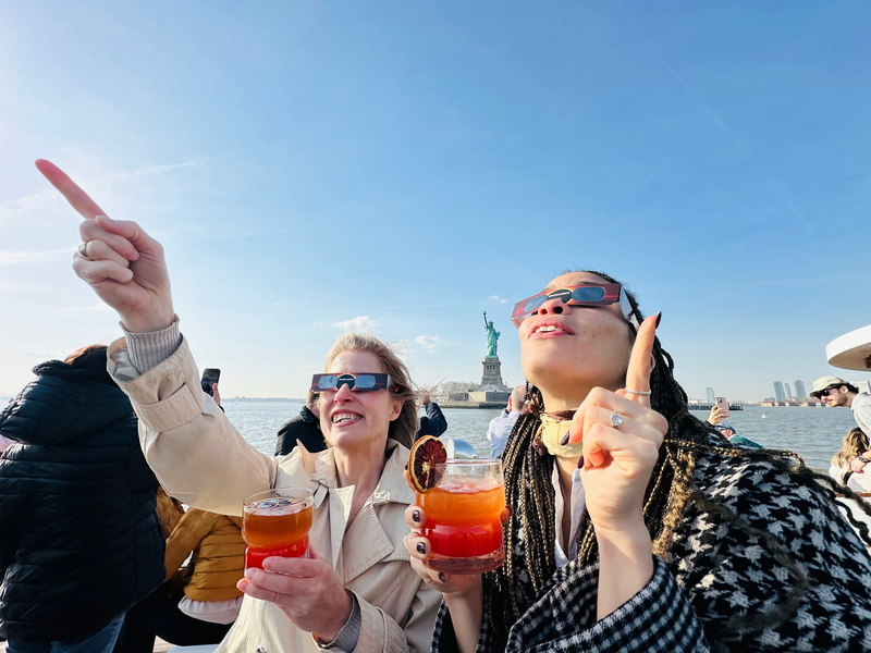 People pointing up and looking into the sky with eclipse glasses