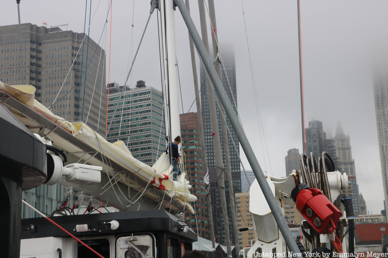 One of the sailboat's mates works on the mast aboard the Grain de Sail ll.