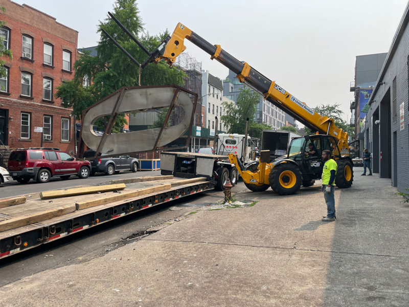 Domino Sugar sign "O" being lifted onto a flatbed truck