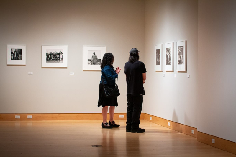 Two people look at photographs on the wall of the Peter Hujar exhibit at the Ukrainian Museum