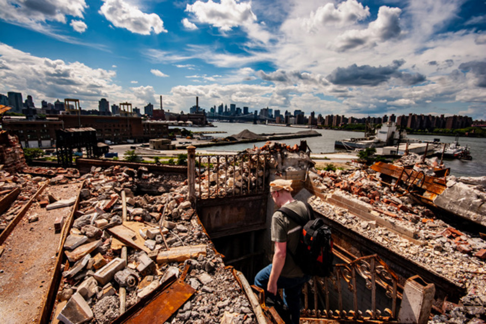 A man walks through debris on the waterfront of the Brooklyn Navy Yard