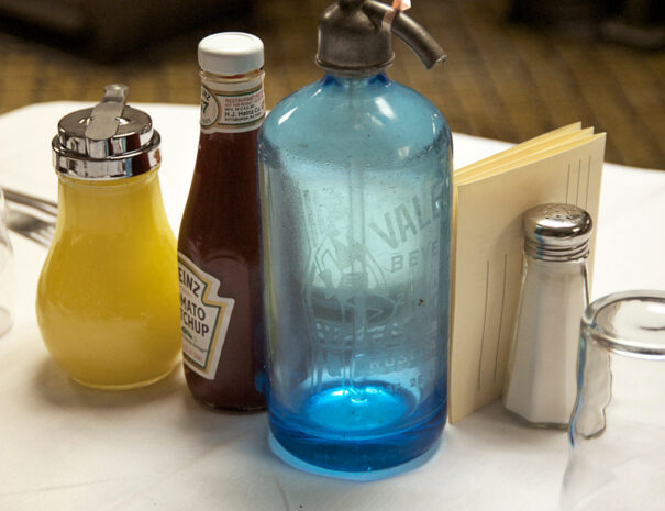 Seltzer bottle and salt and pepper shakers on a table