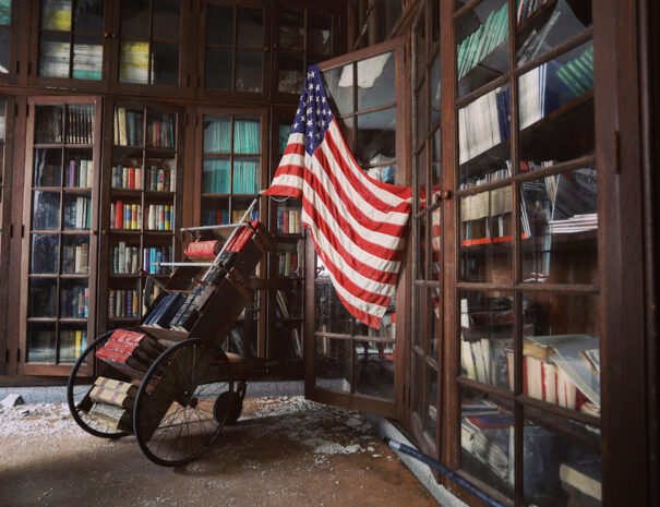 abandoned library with an American flag and wheelchair in the middle of the room