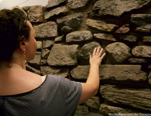 Remnants of New Amsterdam TourWomen touching remnant of Dutch Wall