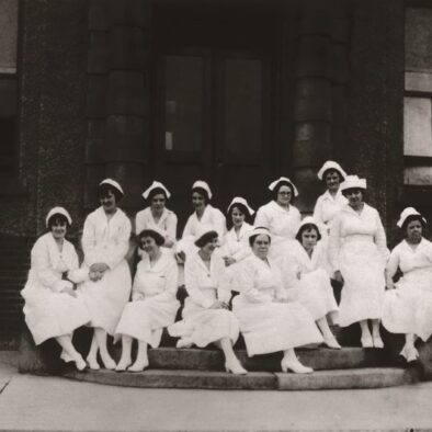 Group of nurses sitting on the steps of the hospital