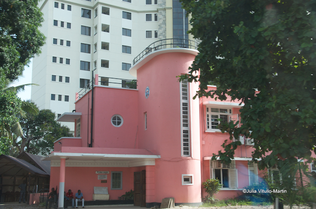 Dar Pink colonial in front of high-rise