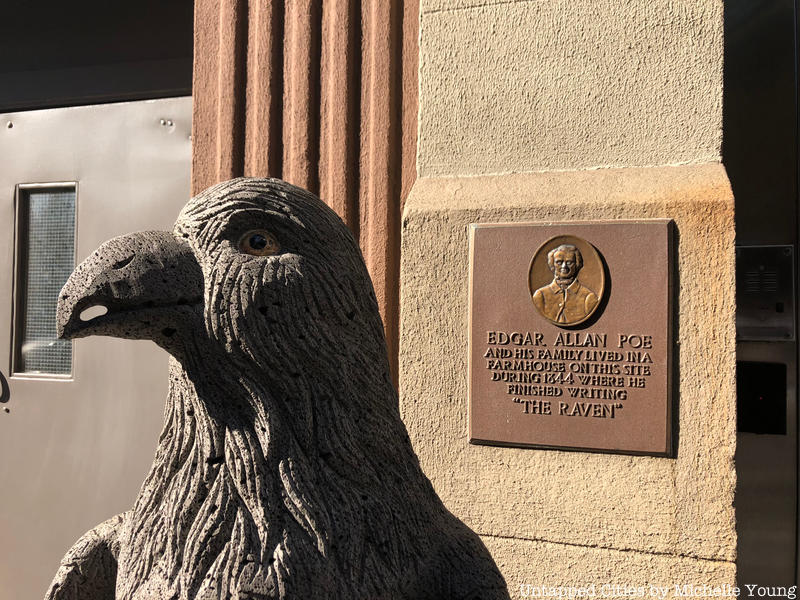 A raven statue stands in front of a plaque that marks the site of the Brennan Farmhouse Site where Edgar Allan Poe wrote "The Raven"