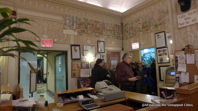 Conrad Strohl, owner of the Edison Cafe' greets a constant stream of patrons. Above the doors you will see rows of foreign currency that had been left at the tables over the years. To the left is an open door leading into the hotel lobby. To the right, the door leading to 47th Street. 