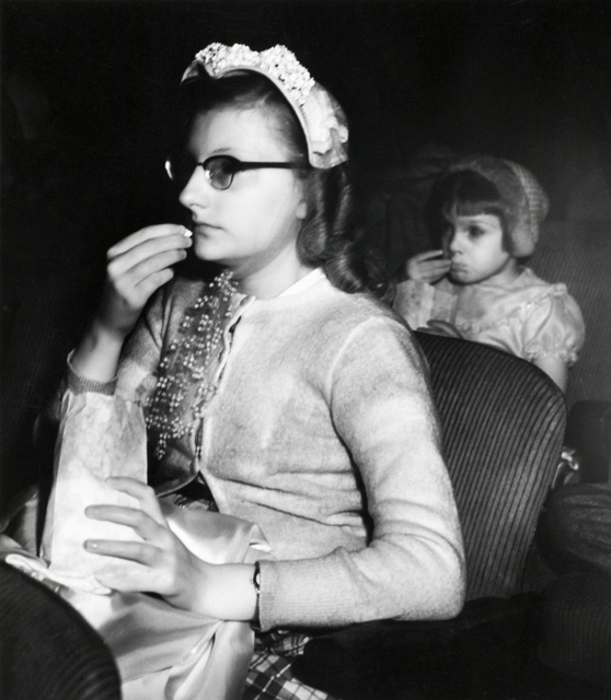 Weegee-Girl-eating-popcorn-in-movie-theater-International Center of Photography-NYC