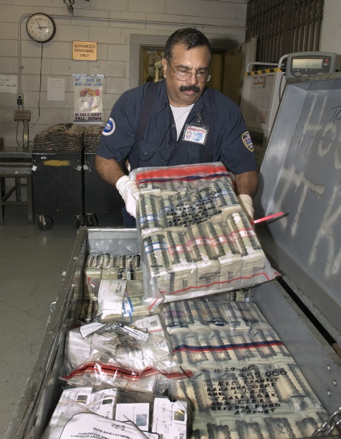 A man puts bags of cash inside a box to go on the money train