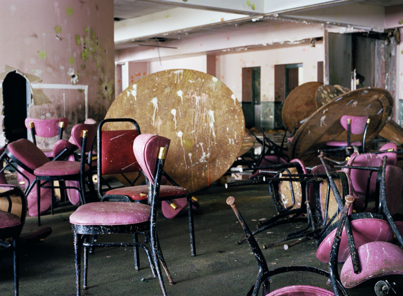 Pink chairs and round wooden tables splattered with paint  in the Borscht Belt