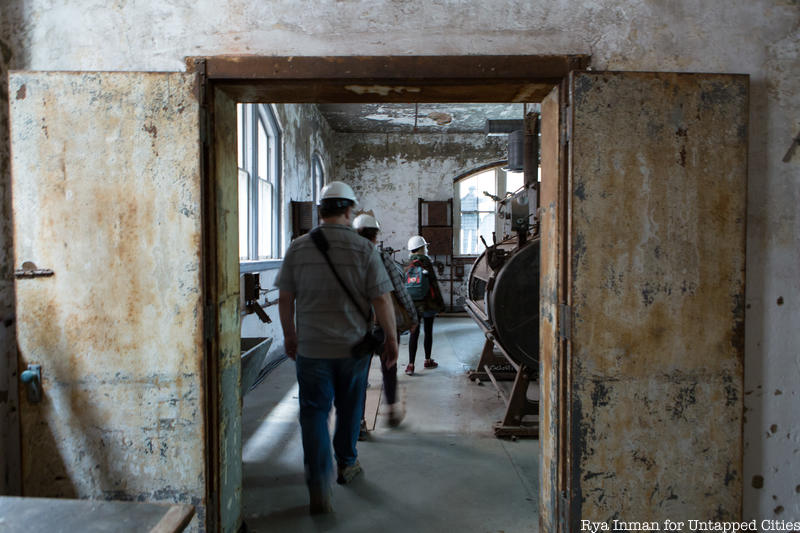 People in hard hats walk through an abandoned hospital
