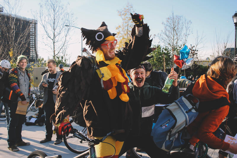 A man in a turkey costume celebrates with a crowd of people at Cranksgiving, one of many Thanksgiving events in NYC