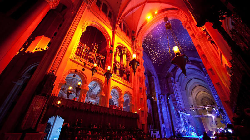 Orange and blue lights illuminate the inside of the Cathedral of St. John the Divine