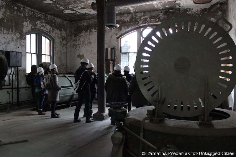 Tour guests inside the former laundry facilities of Ellis Island's abandoned hospital