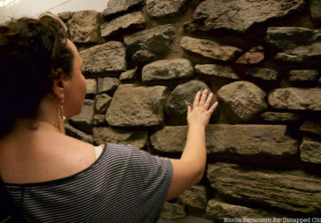 A tour guest touches an 18th century wall