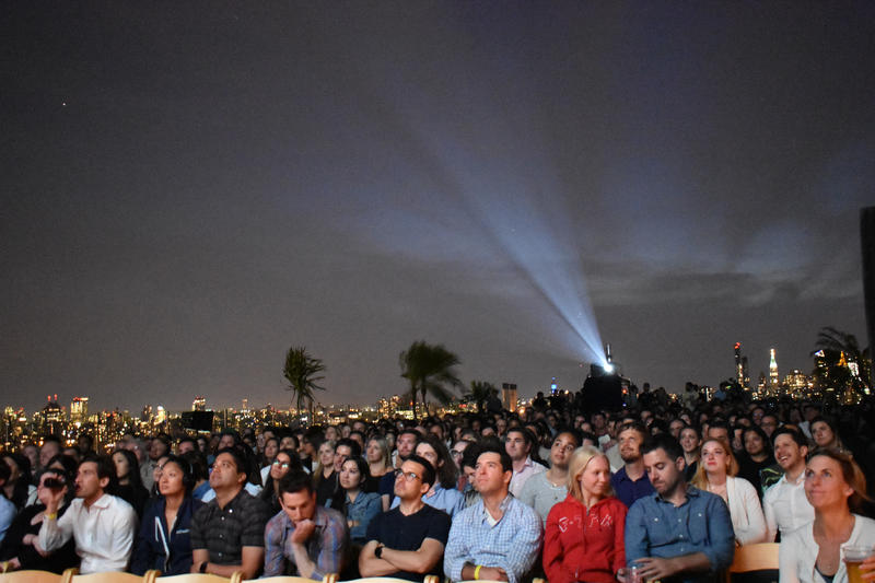A rooftop films crowd watching an outdoor movie in NYC