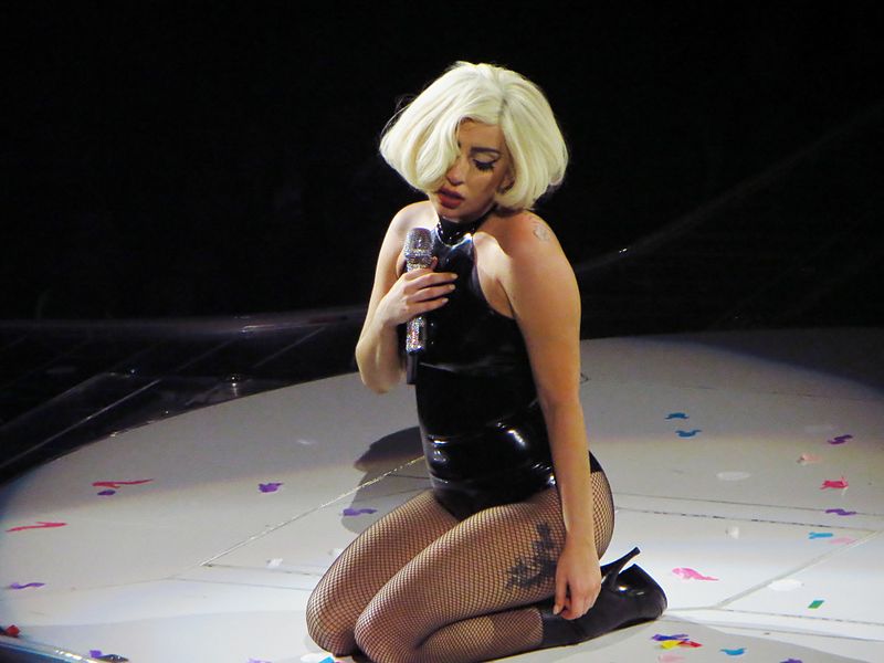 Lady Gaga kneeling on stage