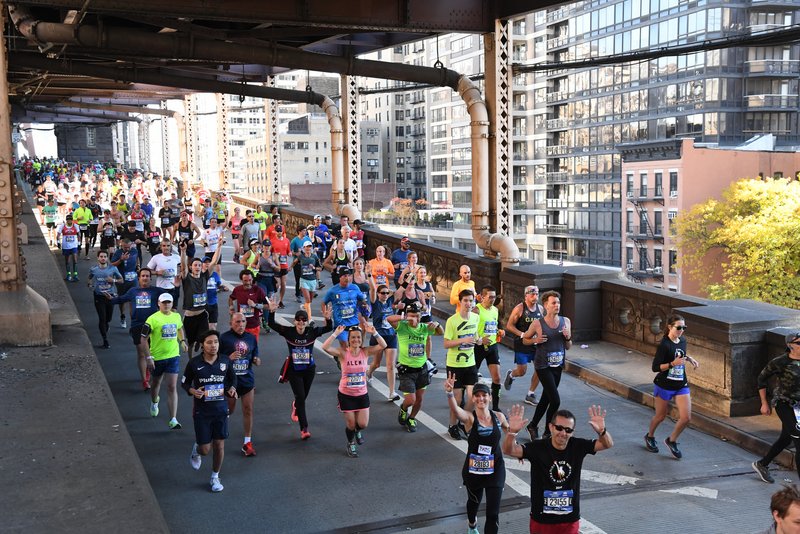 NYC Marathon runners cross a bridge