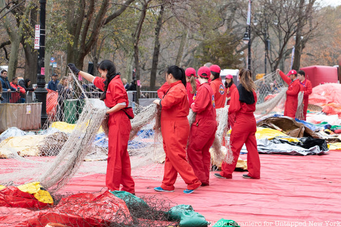 Workers lay a net over the un-inflated form of a Macy's Thanksgiving Day Parade