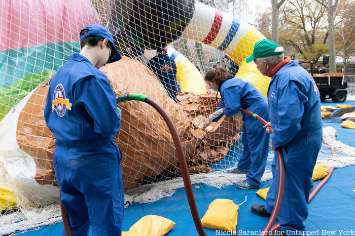 Workers attach an air hose to one of the Macy's Thanksgiving Day Parade balloons