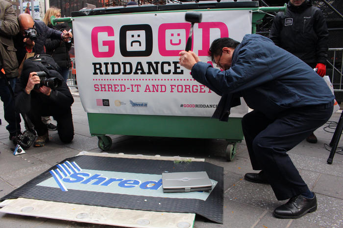 A man smashes a laptop in Times Square for Good Riddance Day