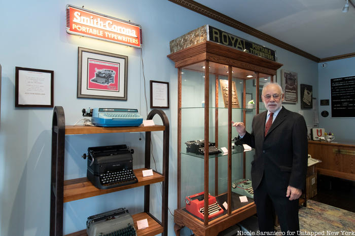The owner of Gramercy Typewriter Co. stands in front of rows of typewriters