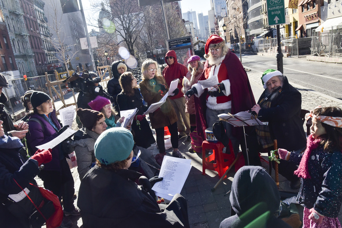 A group of carolers and Santa on the street