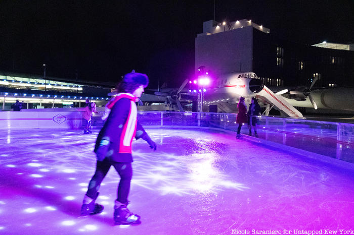 Guests skating on an ice rink at the TWA Hotel