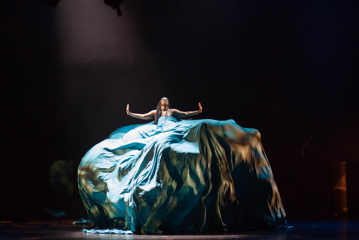 A performa floats above The Apollo stage in a flowing gown