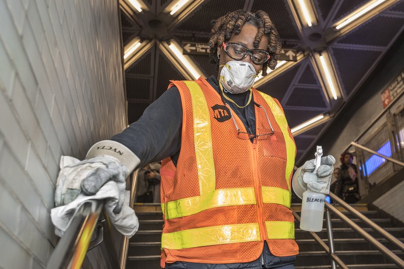 MTA workers disinfecting handrails in subway