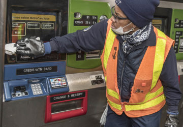 MTA worker disinfecting MetroCard machine