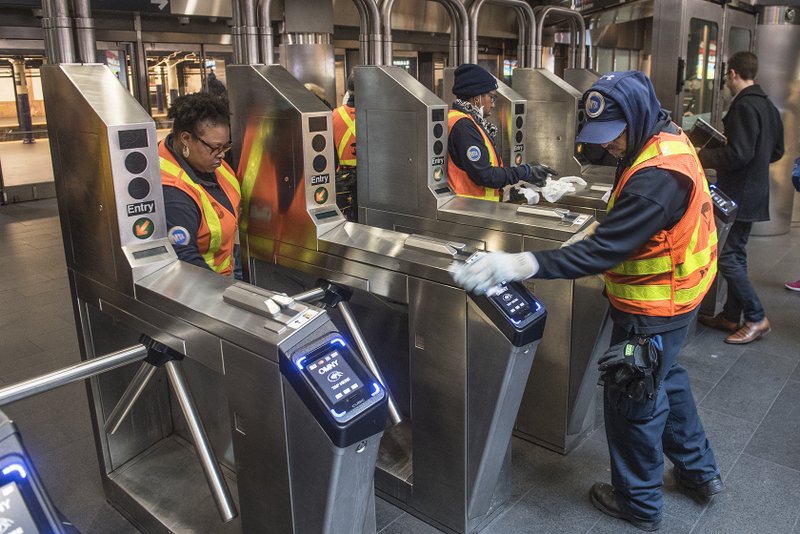 MTA workers disinfecting turnstiles in subway