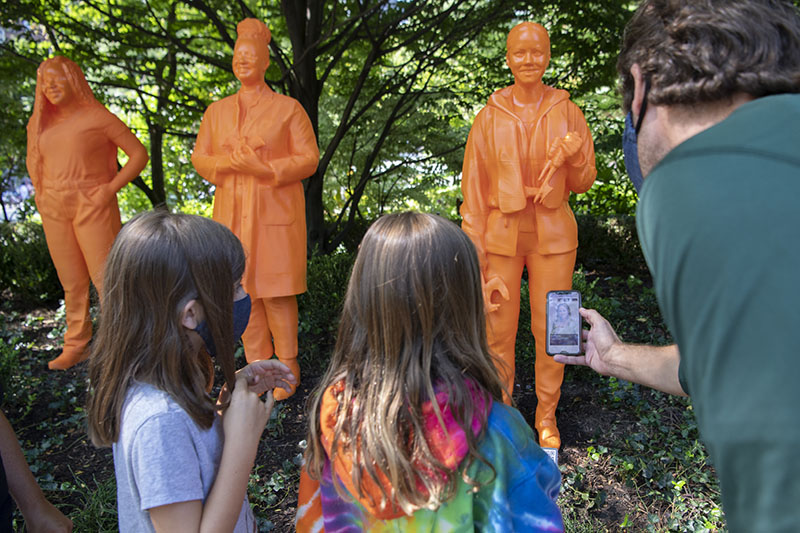 Girls looking at IfThenSheCan sculpture