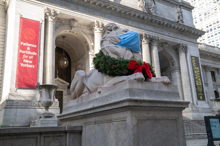 NYPL lion with a wreath around its neck