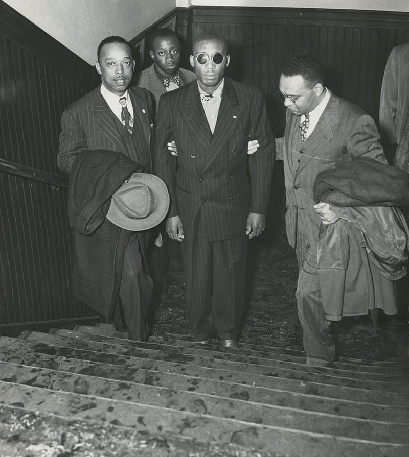 Courtesy of Courtesy of the AFRO American Newspapers Archives  Caption: Front, left to right: Leroy Carter, Isaac Woodard, and Donald Jones, NAACP assistant field secretary. Willie Mabry, Sgt. Woodard’s cousin. in background. Likely taken while Woodard was on his speaking tour with the NAACP. 10/1946.   