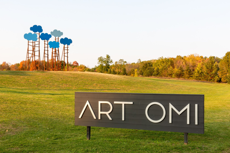 Sign for Oar Omi with cloud sculpture in background