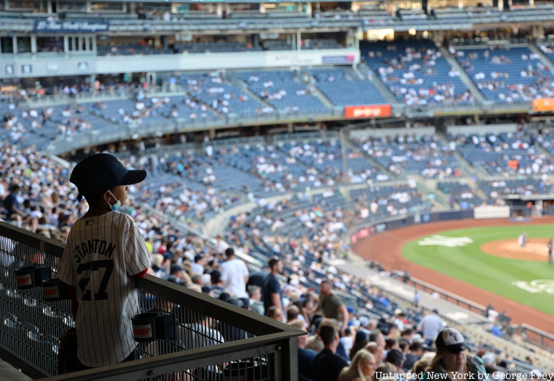 A young boy staring at the Yankees game. 