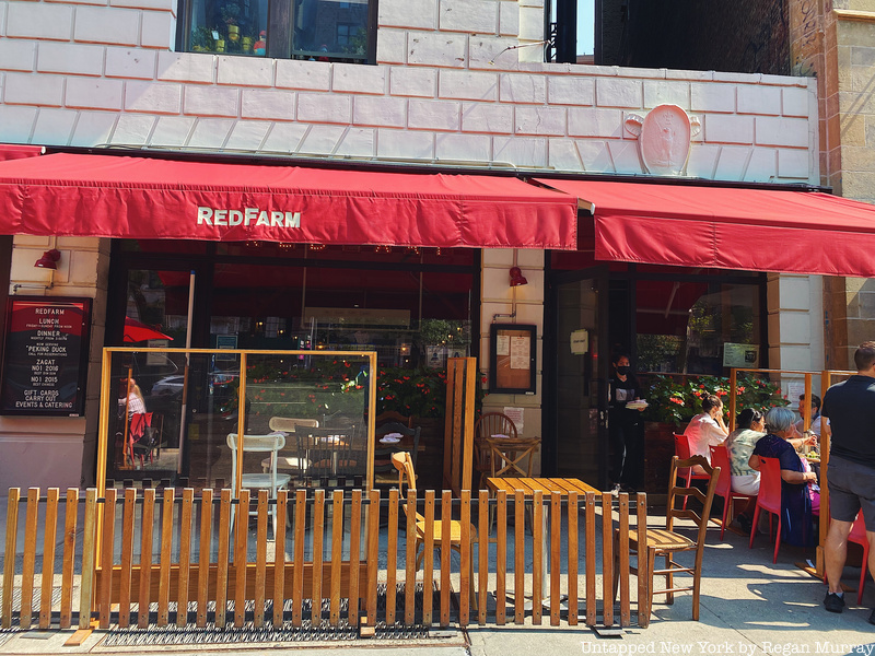 The outside of RedFarm features red awnings and black-paned floor-to-ceiling windows