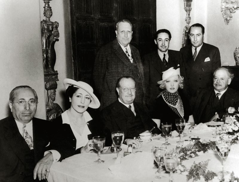 Front row left to right: Louis B. Mayer, Baroness Phillipe de Rothschild, Colonel Henry Roosevelt, Marion Davies and Baron Henri de Rothschild. Back row left to right: William Randolph Hearst, Irving Thalberg, Hal Wallis