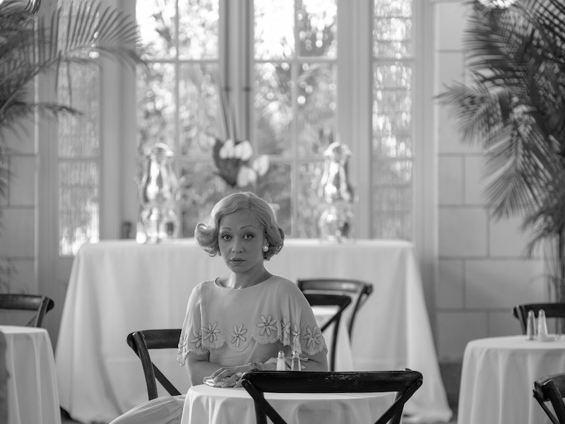 a woman seated at a table in the movie Passing on Netflix
