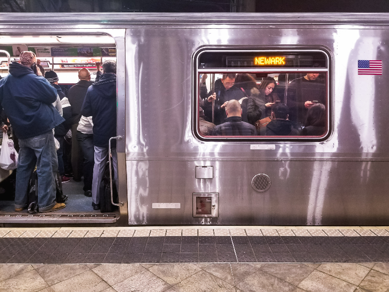 A train bound for Newark Penn Station waits at a platform.