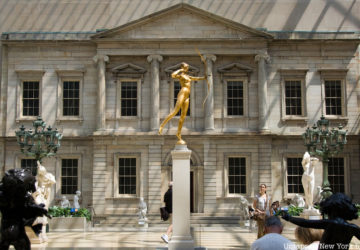 A gold statue stands at the center of the American Wing at the Metropolitan Museum of Art