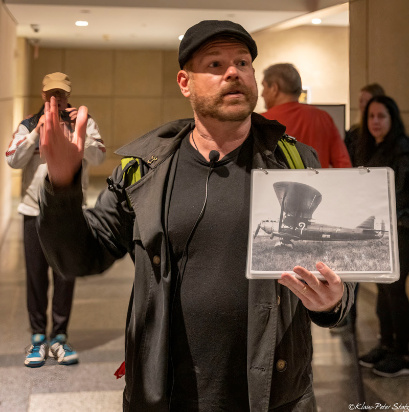 Tour guide Justin Rivers holds up an image of the original plane that inspired the silver Cartier plane model