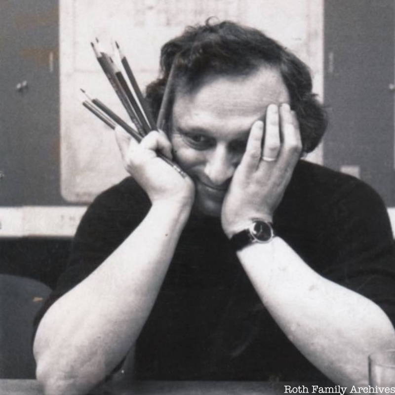 Architect Richard Roth Jr. smiles towards the side of the camera while holding a handful of pencils to his face