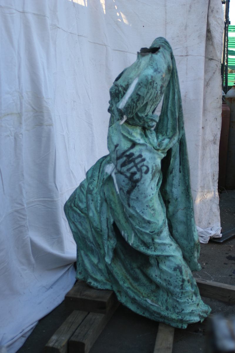 The headless statue of Fame set against a white backdrop