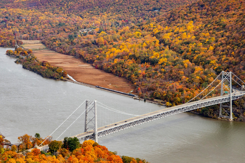 The George Washington Bridge surrounded by foliage and a vintage train